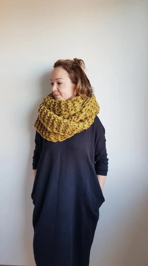 Person wearing a yellow knitted scarf against a white background