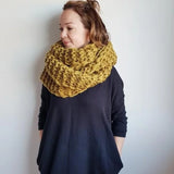 Person wearing a yellow knitted scarf against a white background